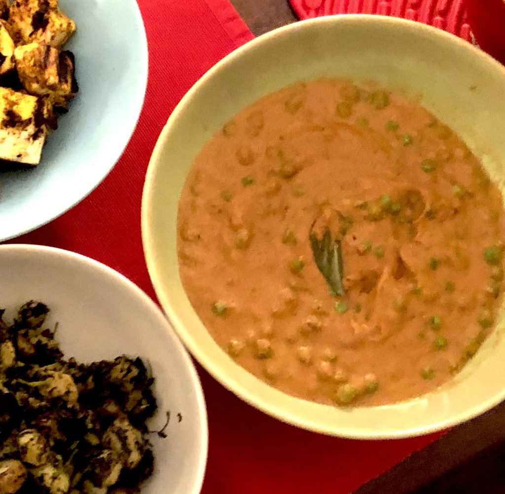 Vegan Creamy Cashew Curry Sauce with peas as part of a curry dinner